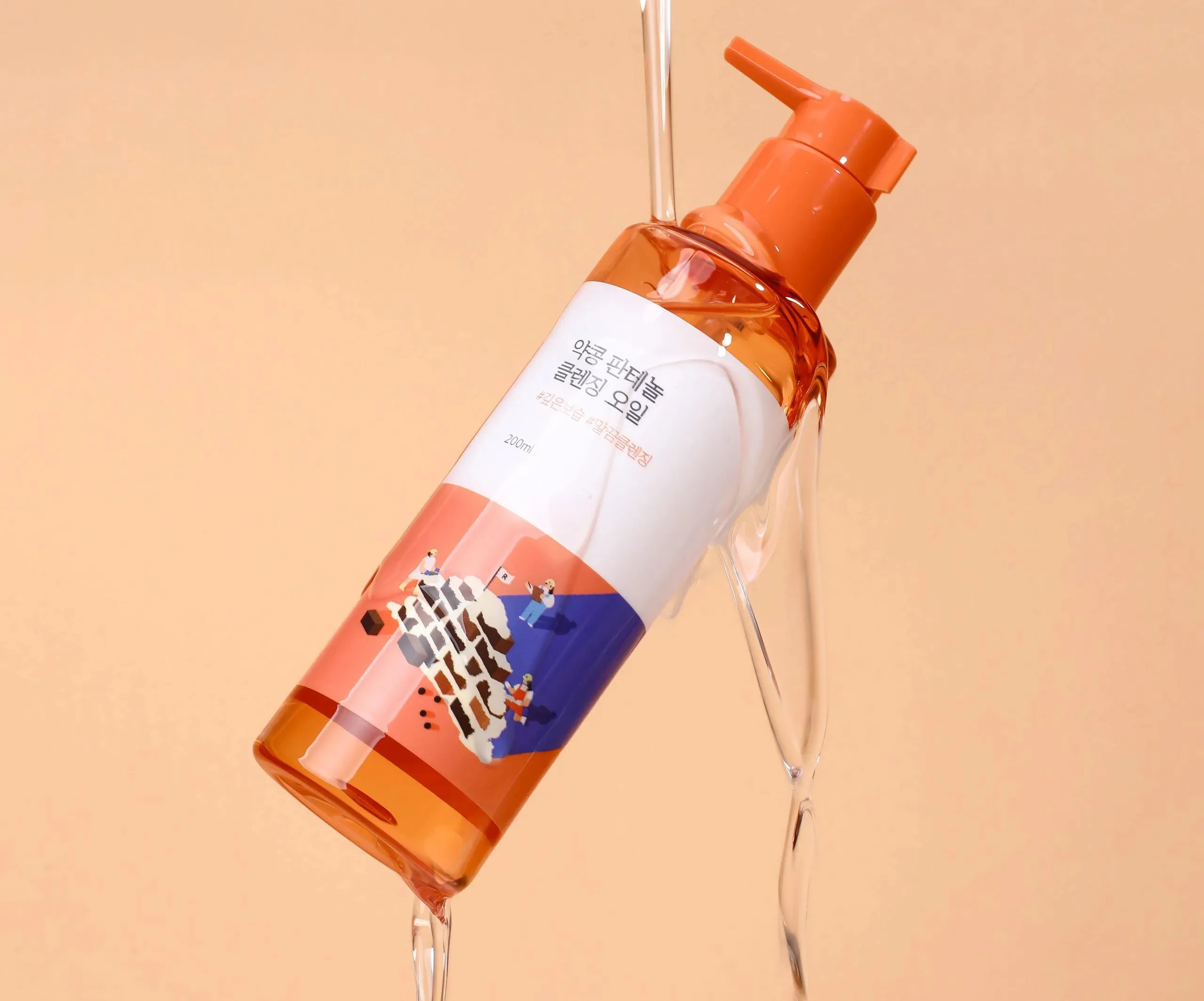 Prezentarea produsului ROUND LAB Ulei hidrofil Soybean Panthenol Cleansing Oil sub un jet de apă purificatoare, ideal pentru prima etapă a dublei curățări, dizolvarea sebumului și protejarea barierei cutanate. 